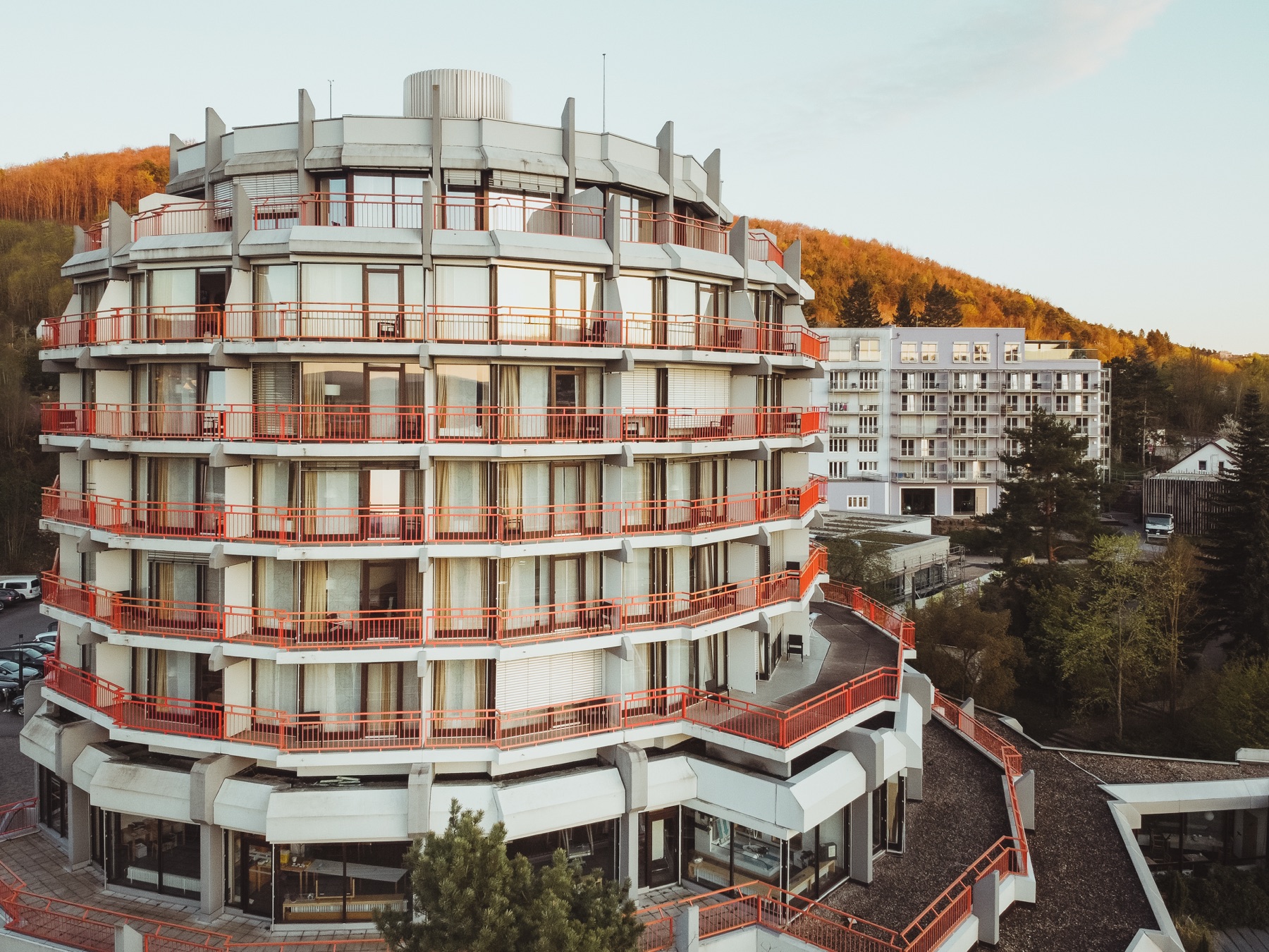 Das Gebäude der Klinik Bavaria im Abendlicht vor einem bewaldeten Hang.